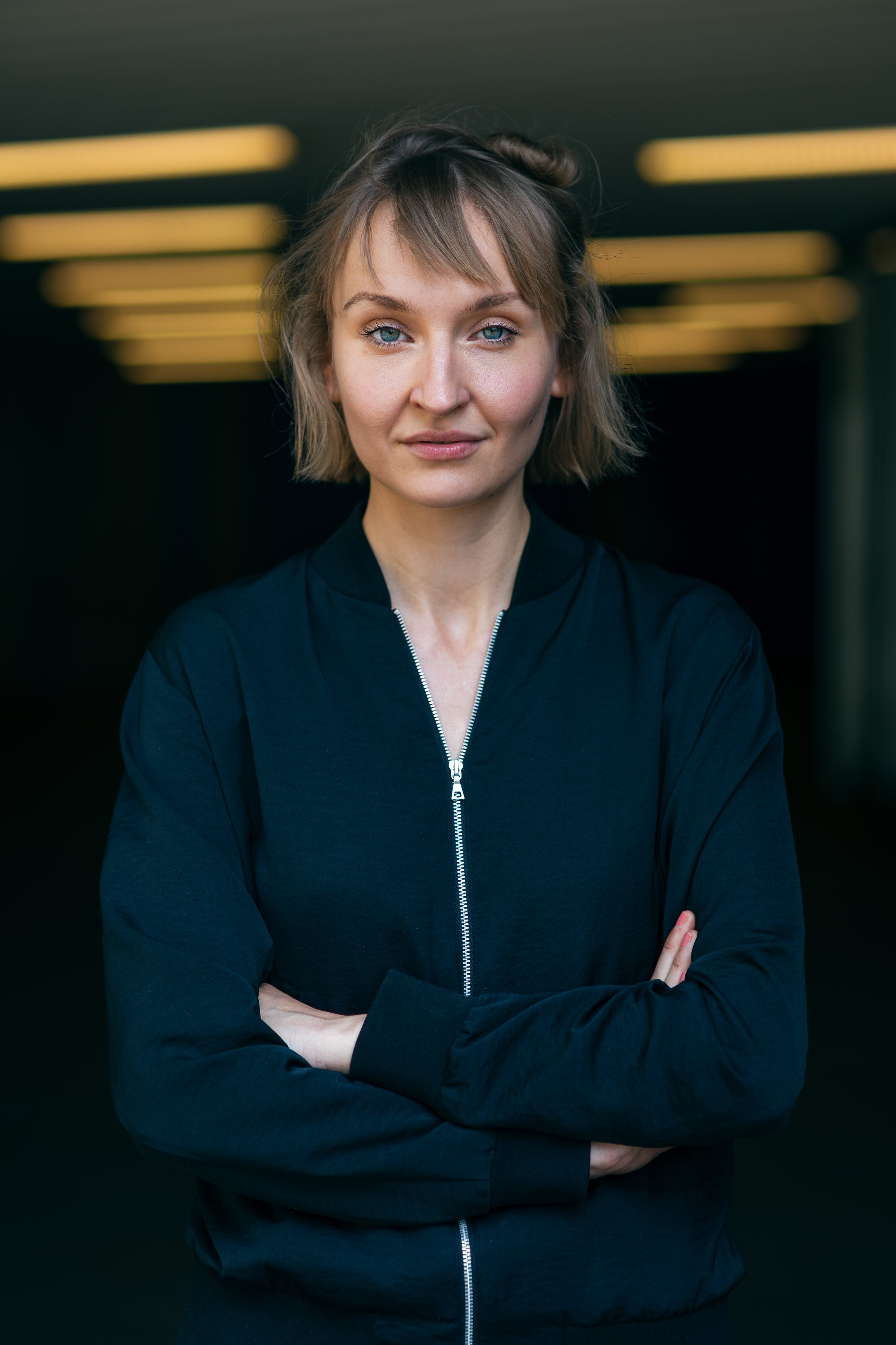 Zu sehen ist eine junge Frau Anfang 30 mit dunkelblonden, kinnlangen Haaren